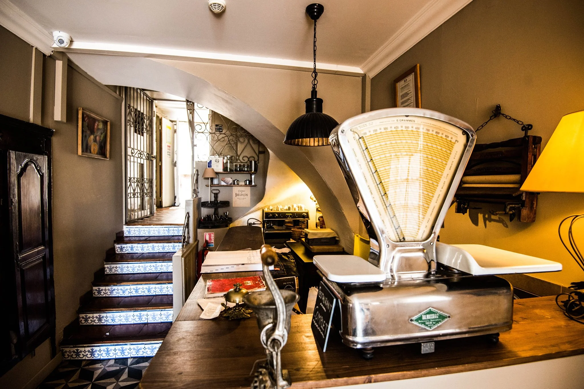 Intérieur chaleureux de L'Auberge Provençale : comptoir en bois, vieille balance et ambiance rustique
