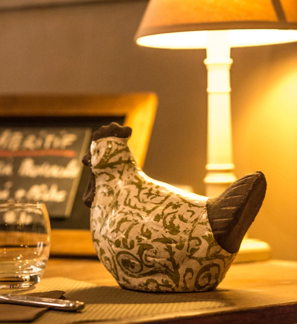 Détail d'ambiance : lampe tamisée et poule en céramique