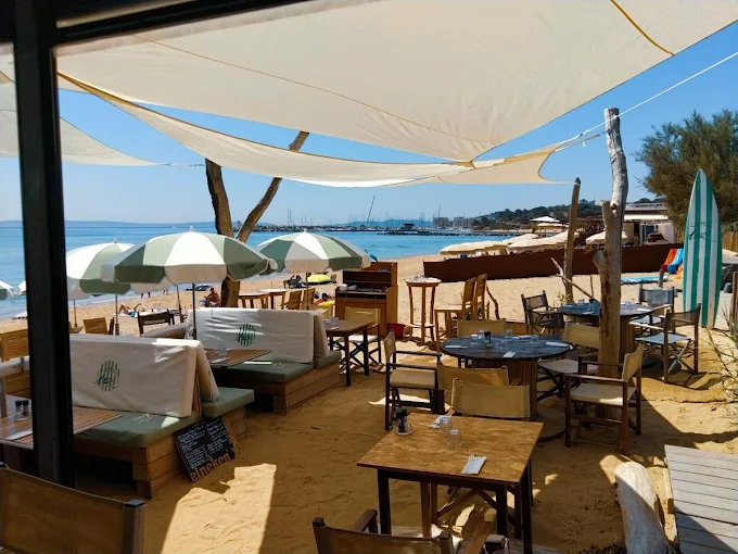 Terrasse de L'Effet Mer sur le sable, sous les voiles blanches et parasols, face à la plage et à la Méditerranée au Lavandou