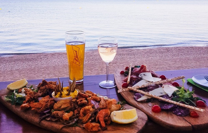 Planches à partager, fritures et charcuterie, face à la plage au coucher du soleil