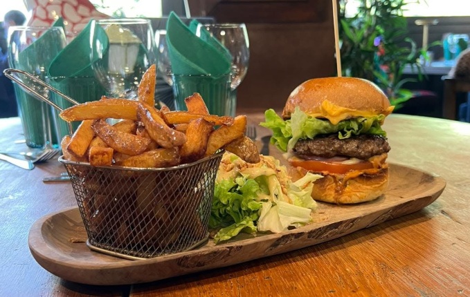 Burger maison et frites maison sur planche en bois, avec salade, au Onze