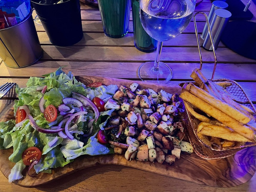Planche de poulpe grillé, salade et frites au Onze, ambiance tamisée