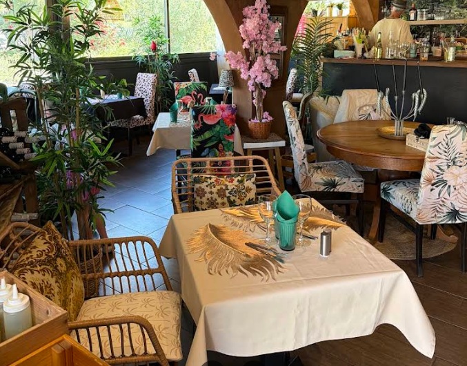 Salle intérieure bohème du Onze : rotin, palmier, chaises tropicales et bar