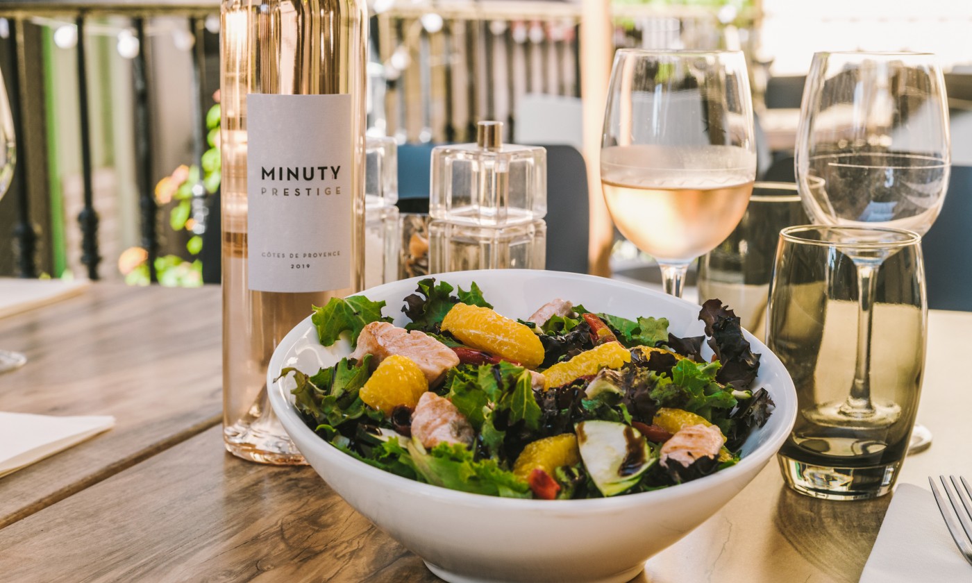 Salade fraîche au saumon et suprêmes d'orange servie en terrasse avec un rosé Côtes de Provence