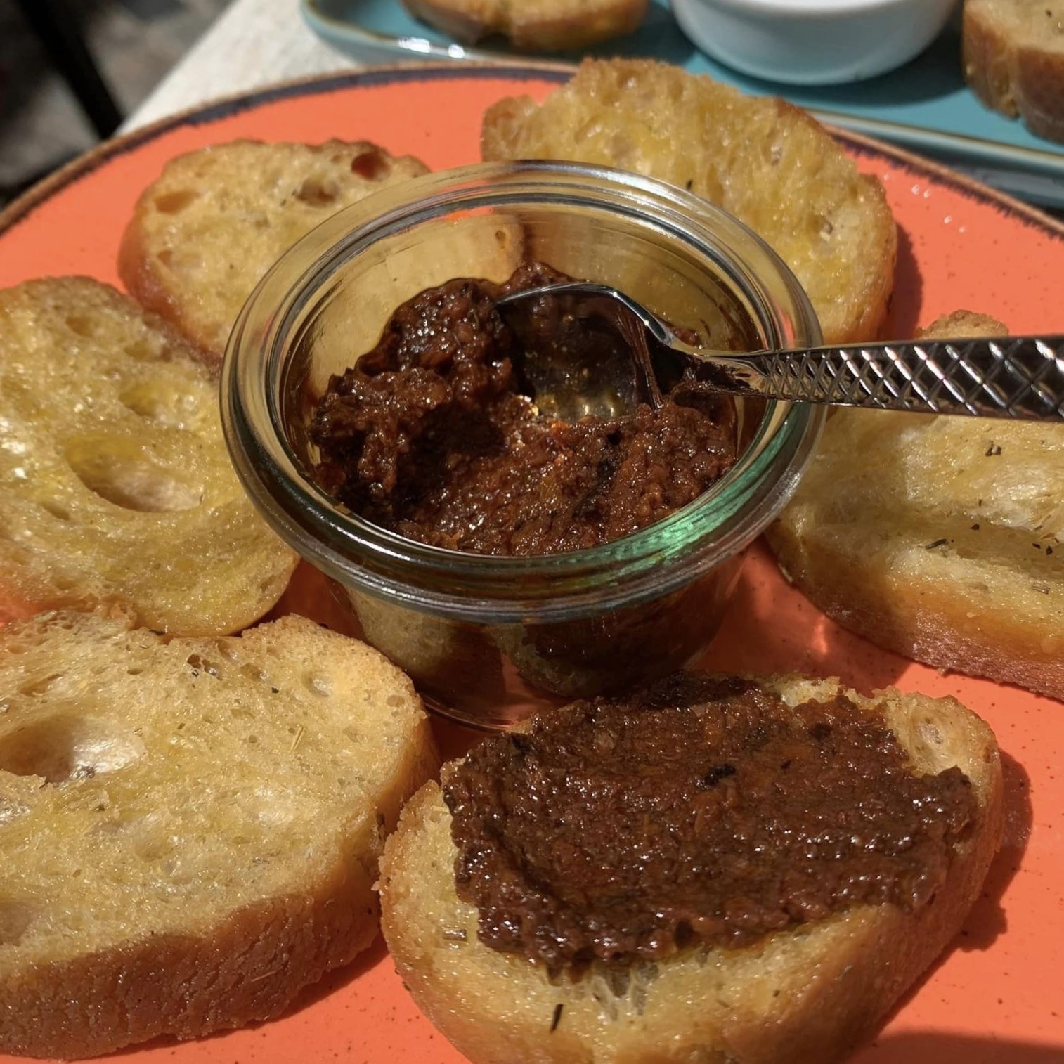 Tapenade d'olives maison servie en petit bocal avec des toasts