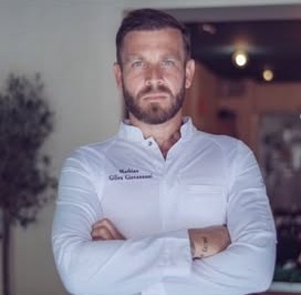 Mathias Gilles-Giovannoni, chef de Pradeau Plage, en veste de cuisine sur la terrasse
