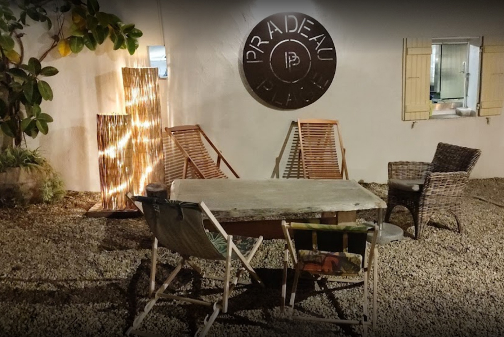 Le coin privé de Pradeau Plage la nuit, logo métal gravé et guirlandes