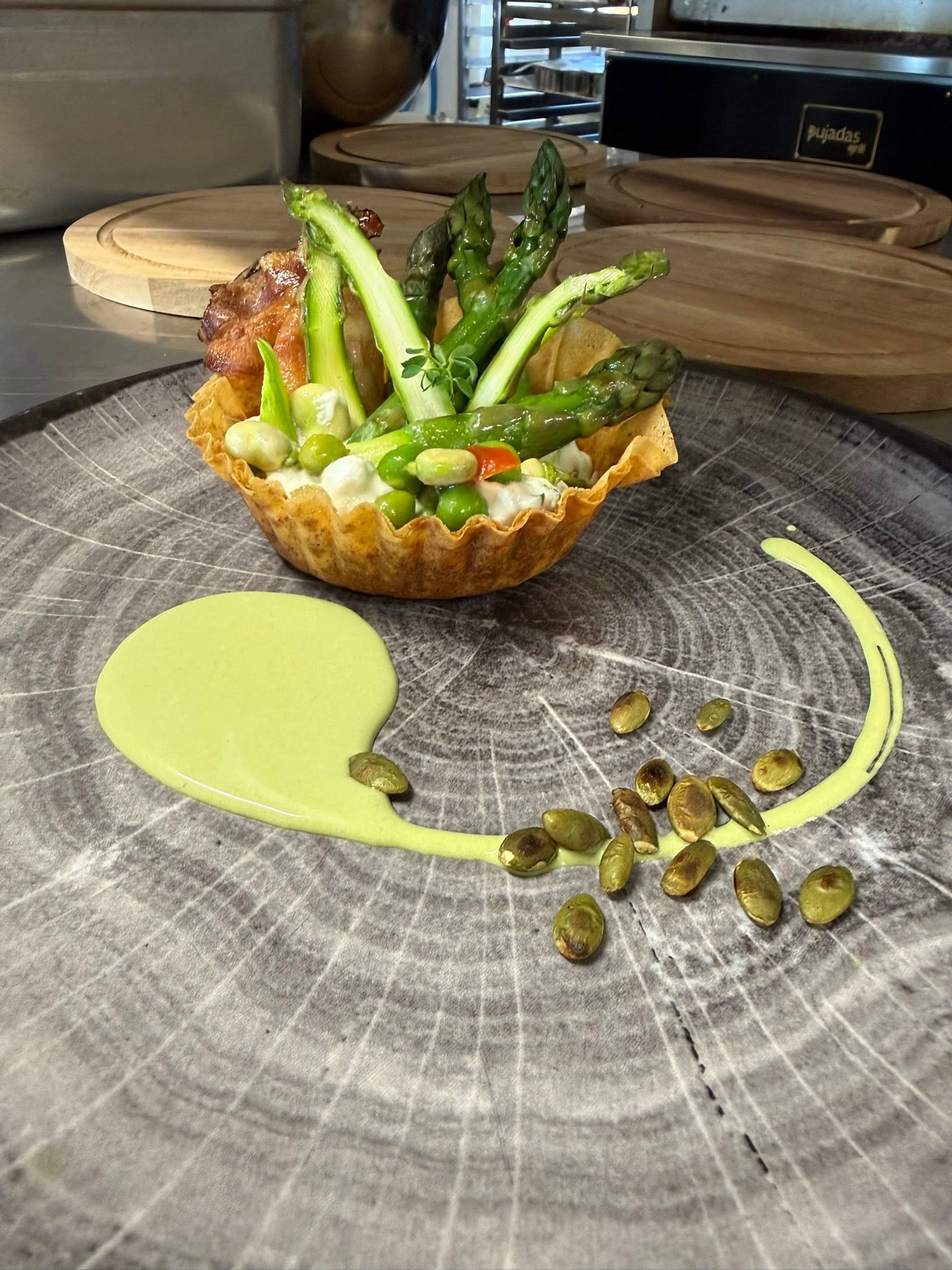 Tartelette croustillante aux asperges vertes, petits pois et crème, seeds de courge torréfiées
