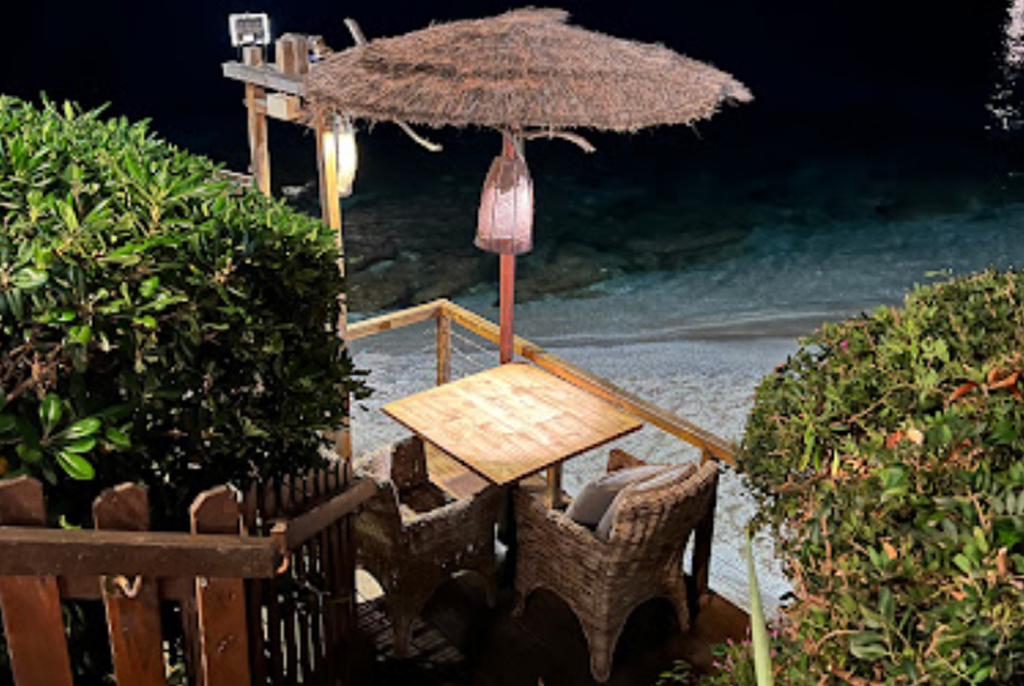 Table intime pour deux au bord du sable, éclairage tamisé le soir