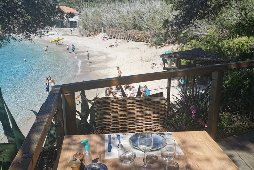 Terrasse en surplomb de la plage de sable et de l'eau turquoise